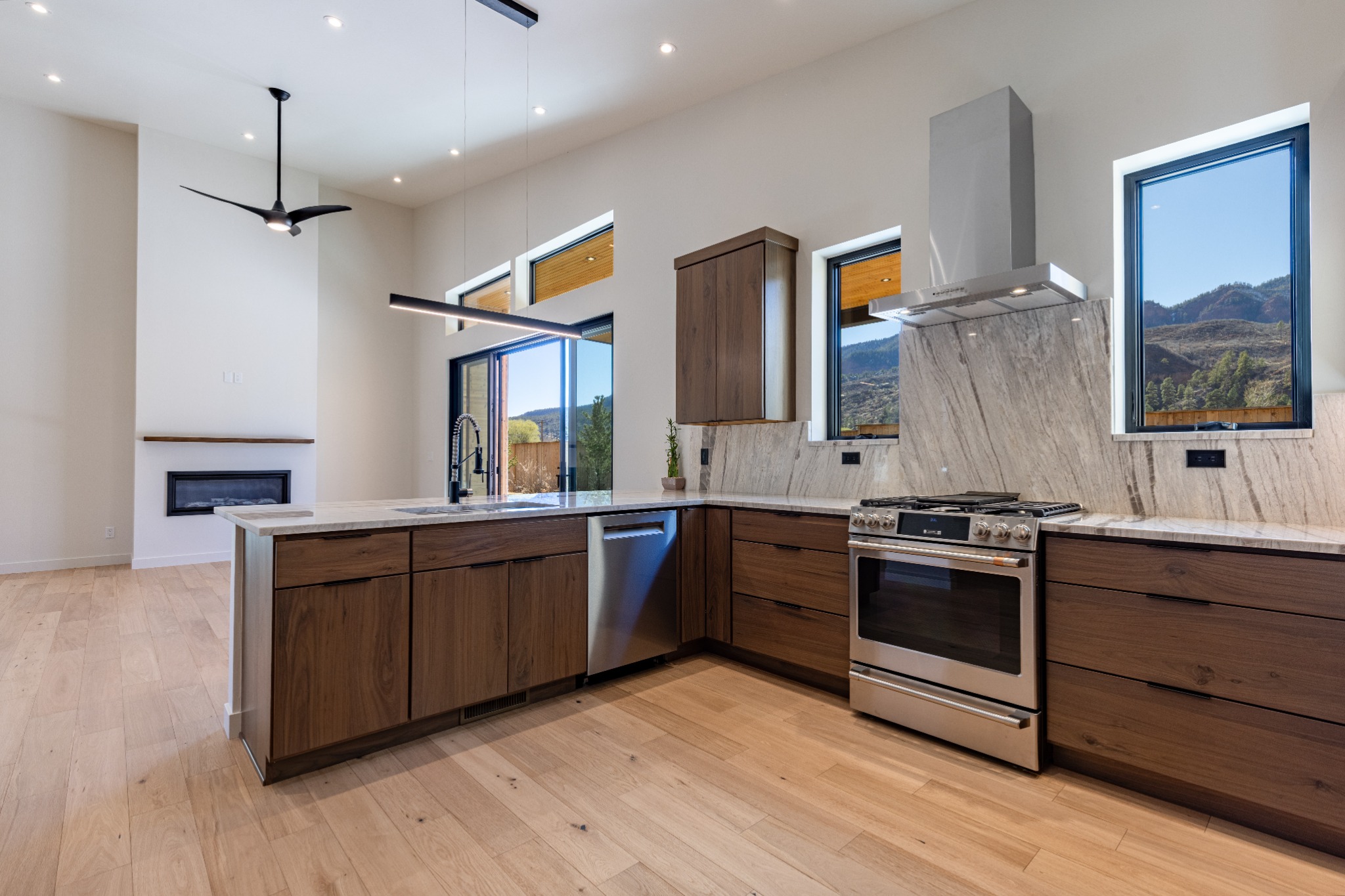 Modern kitchen with warm wood cabinetry and mountain views